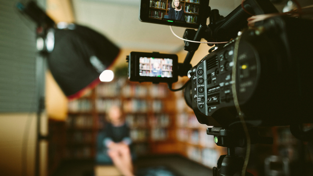 A broadcast setup with a camera, microphone, and lighting.
